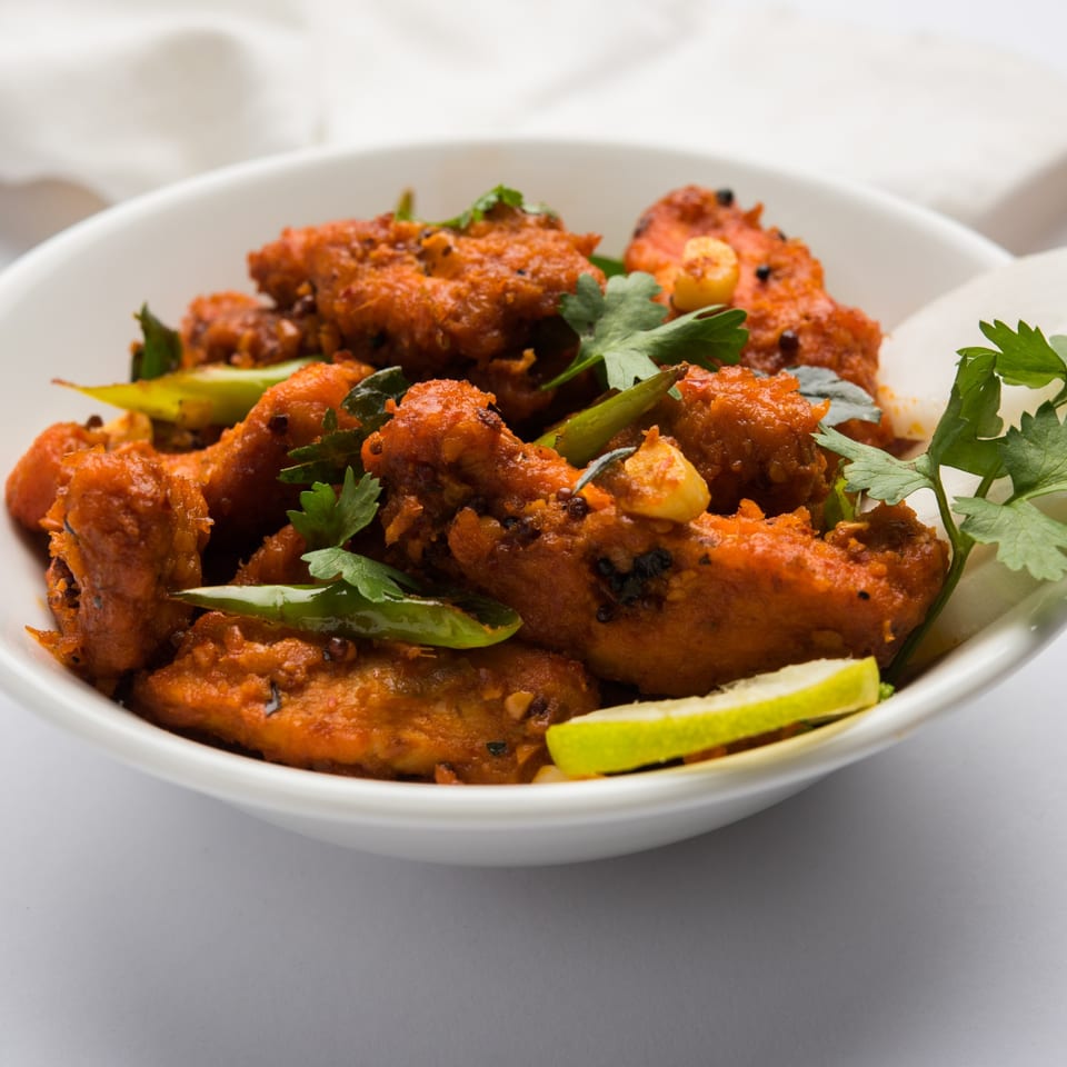 Close-up of Lafa Restaurant's Nepalese chicken chili, garnished with green chilies, cilantro, and lime.